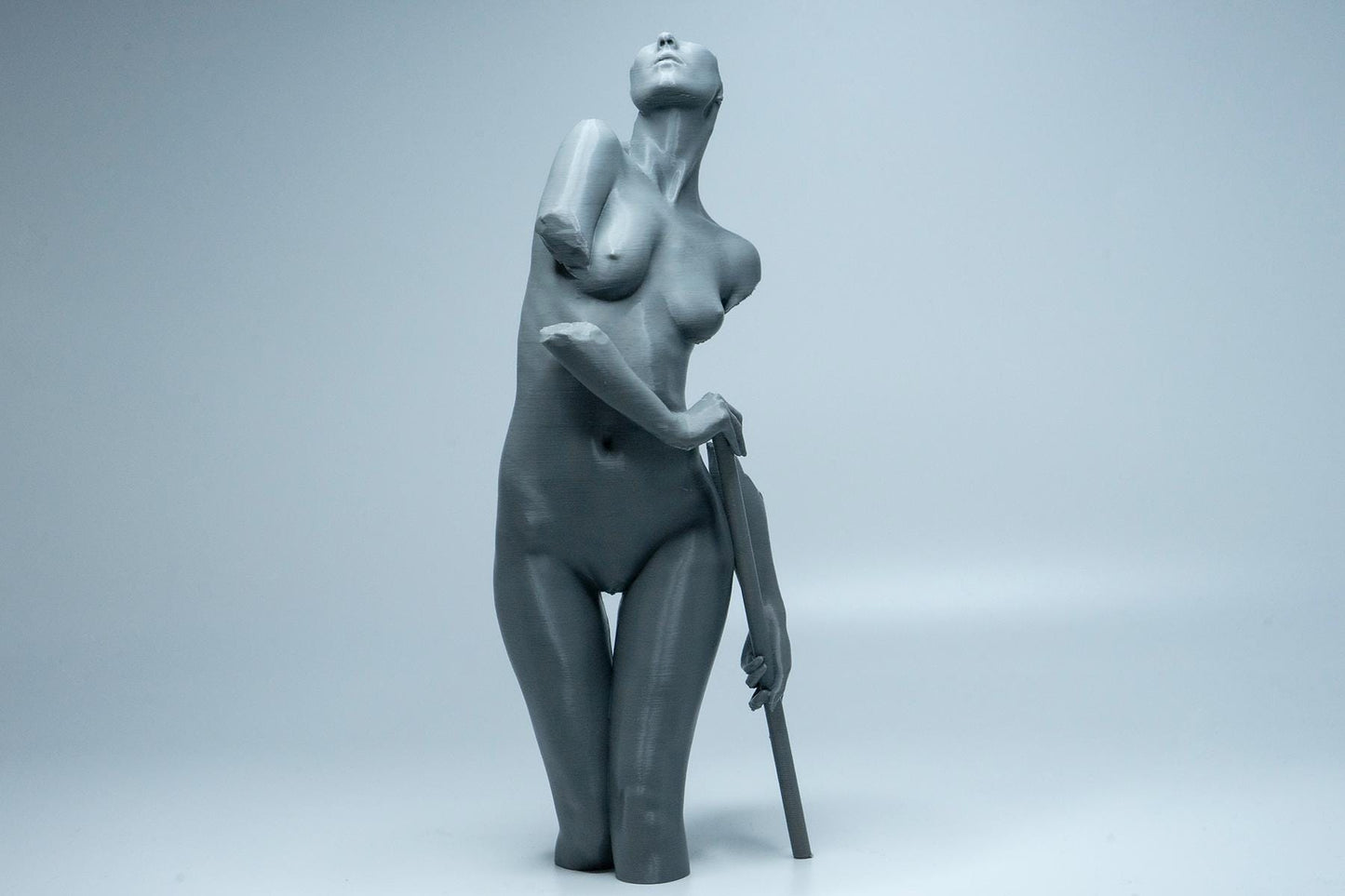 Female figure anatomy model holding prop. Artist reference sculpture for studying weight distribution and structural form.