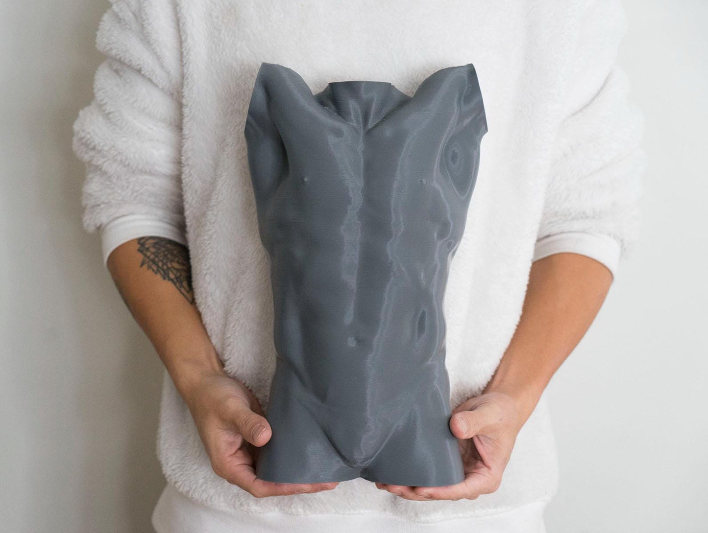 Male torso anatomy sculpture with raised arm for artists. Figure drawing reference model for studying ribcage stretch and muscular structure. holding sculpture