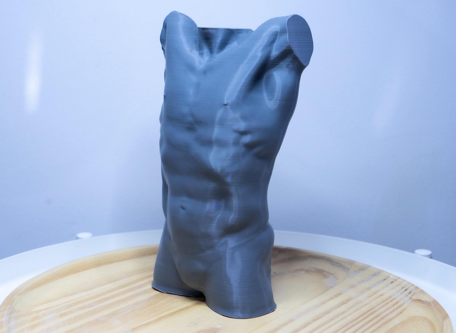 Male torso anatomy sculpture with raised arm for artists. Figure drawing reference model for studying ribcage stretch and muscular structure. grey sculpture