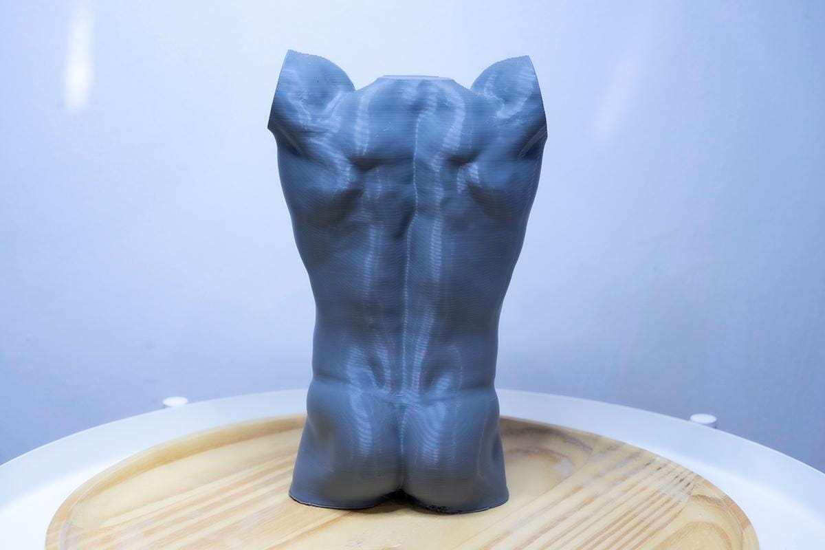 Male torso anatomy sculpture with raised arm for artists. Figure drawing reference model for studying ribcage stretch and muscular structure. grey sculpture