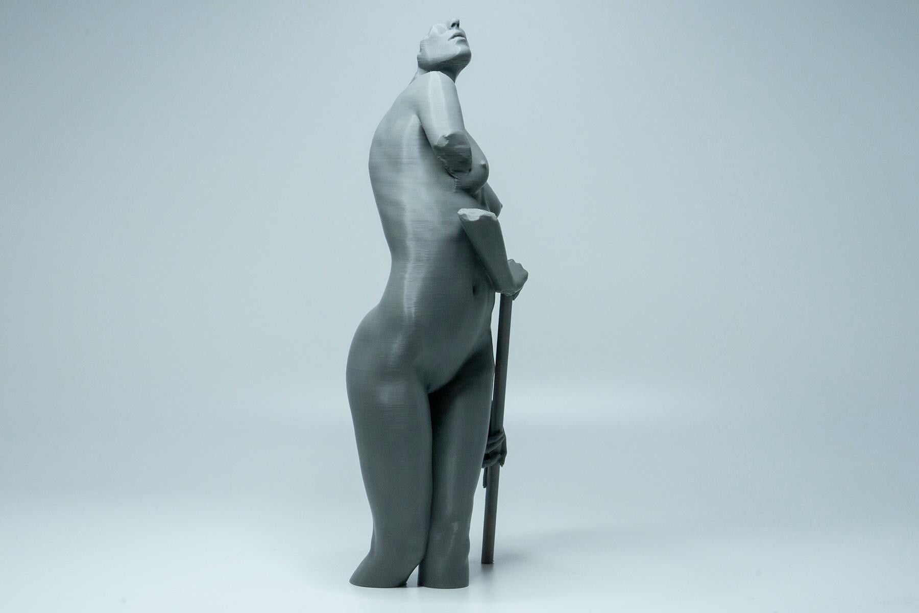 Female figure anatomy model holding prop. Artist reference sculpture for studying weight distribution and structural form.
