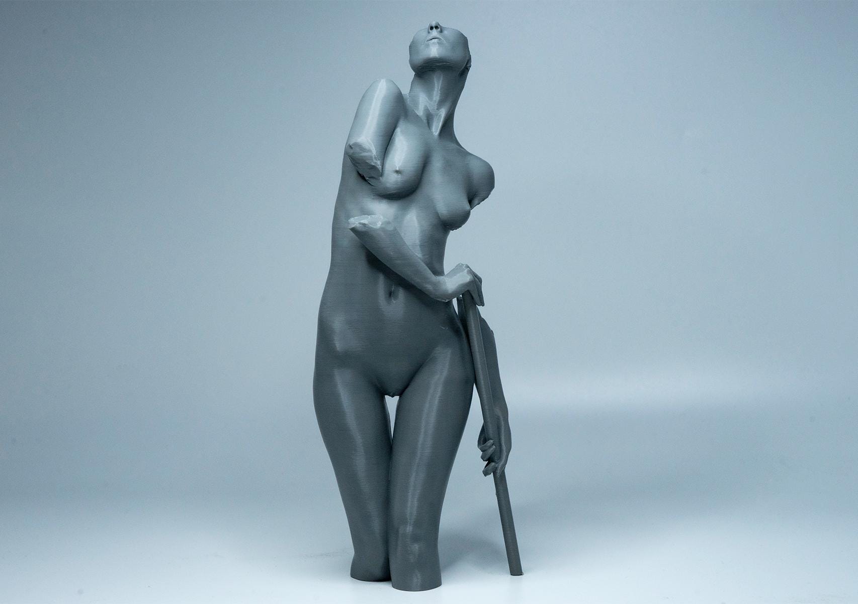 Female figure anatomy model holding prop. Artist reference sculpture for studying weight distribution and structural form.