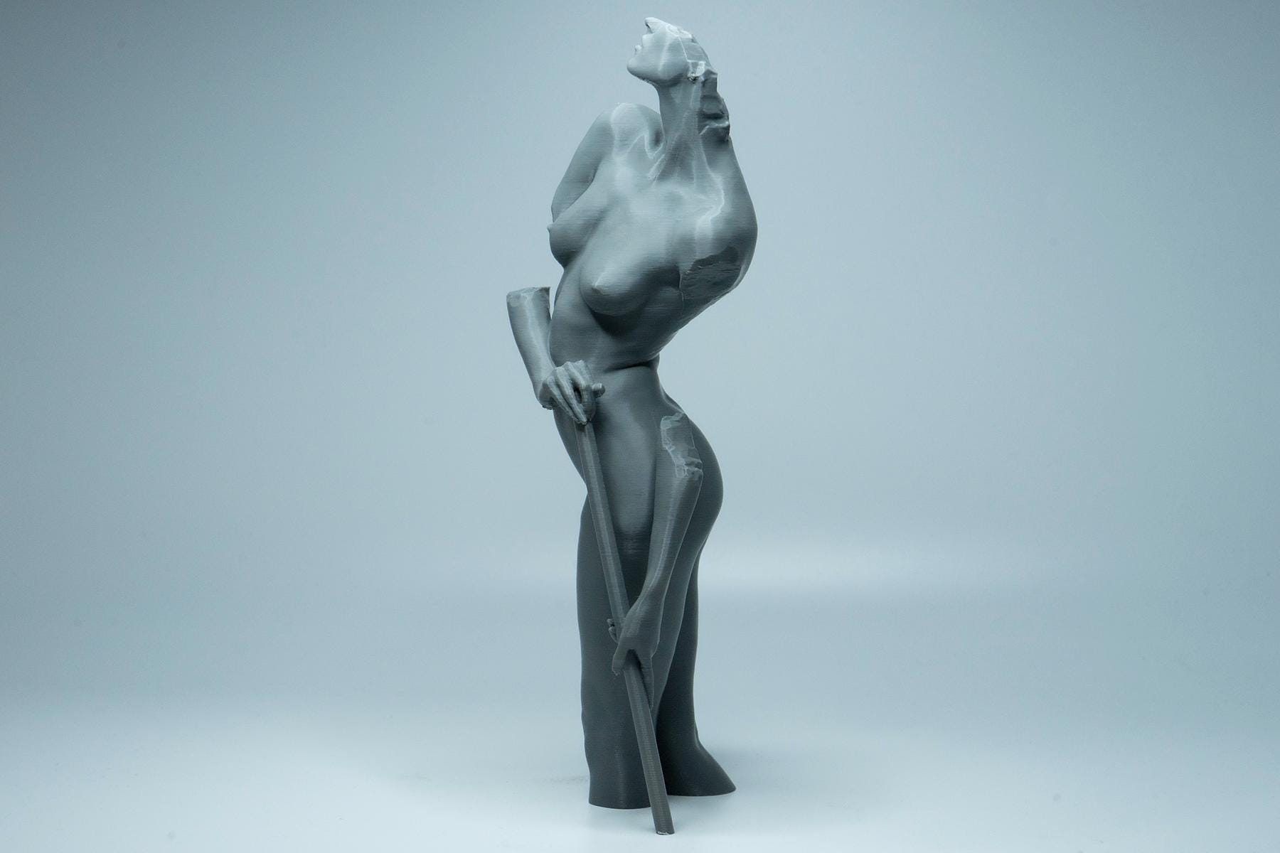 Female figure anatomy model holding prop. Artist reference sculpture for studying weight distribution and structural form.