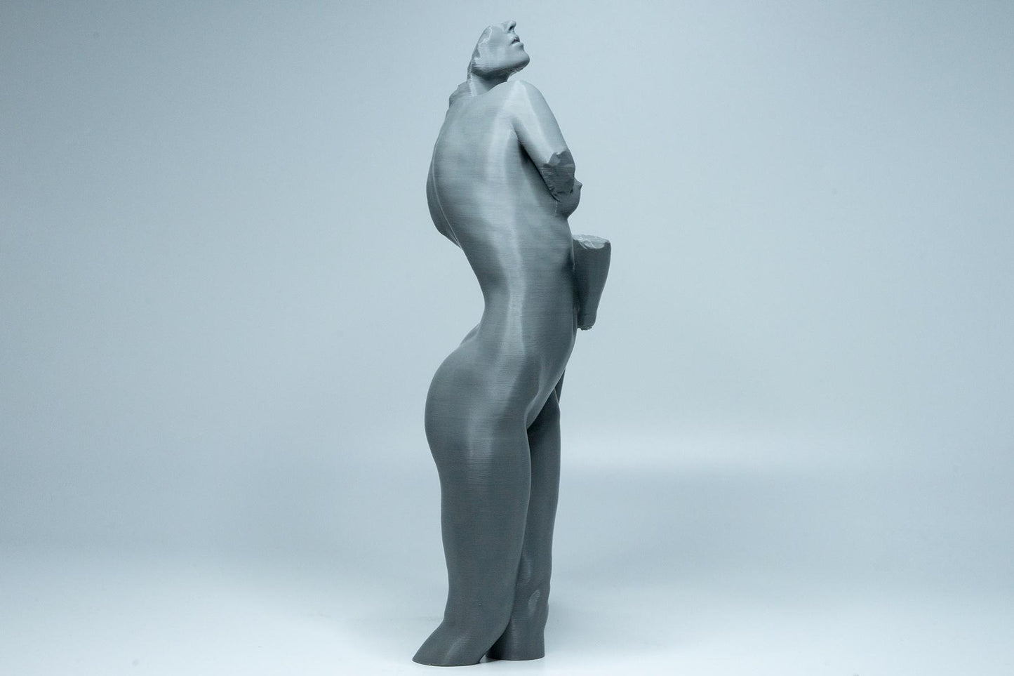 Female figure anatomy model holding prop. Artist reference sculpture for studying weight distribution and structural form.