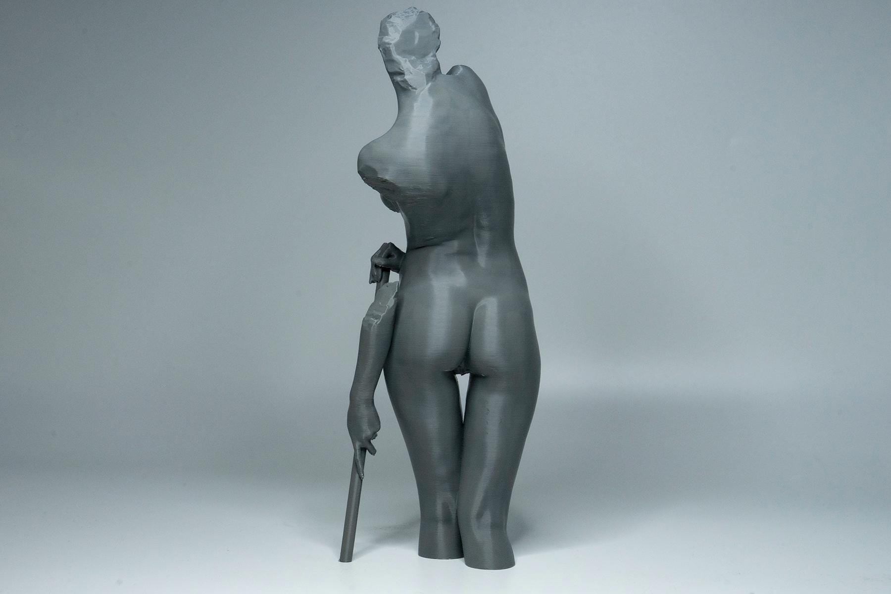 Female figure anatomy model holding prop. Artist reference sculpture for studying weight distribution and structural form.