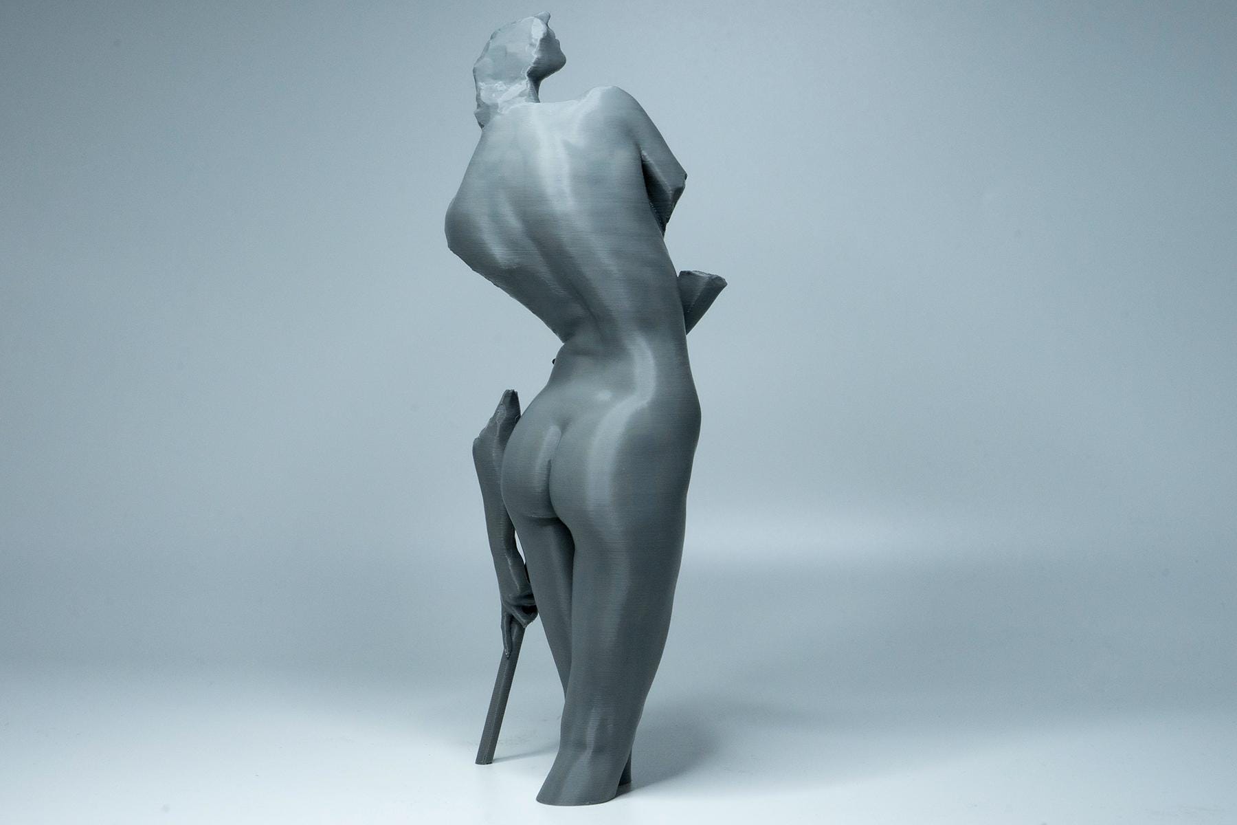 Female figure anatomy model holding prop. Artist reference sculpture for studying weight distribution and structural form.